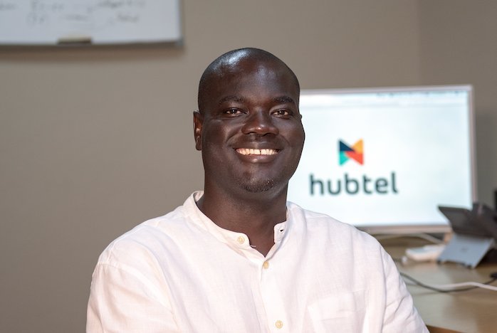 Alex Bram at a desk with the Hubtel logo on screen