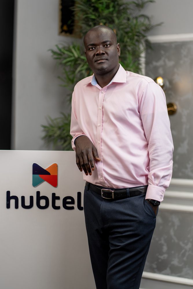 Alex Bram standing beside the Hubtel sign